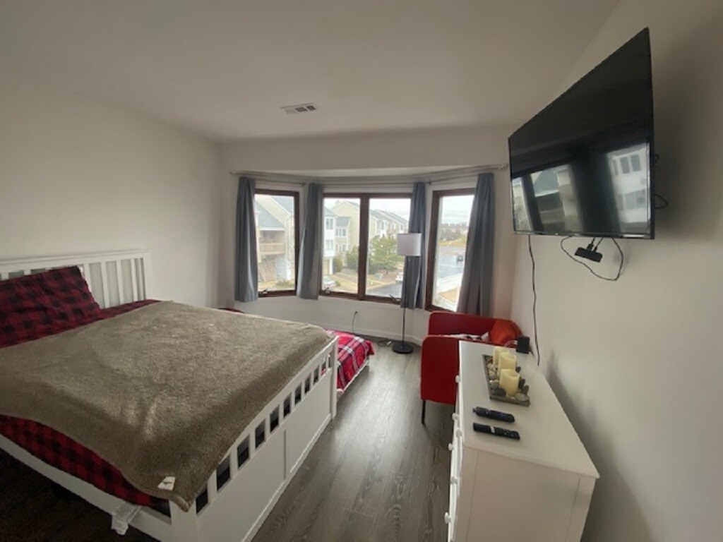 Otra vista de este dormitorio de lujo con una televisión inteligente HDR 4k equipada con un palo de streaming Roku 4K y cientos de canales por cable en vivo. 