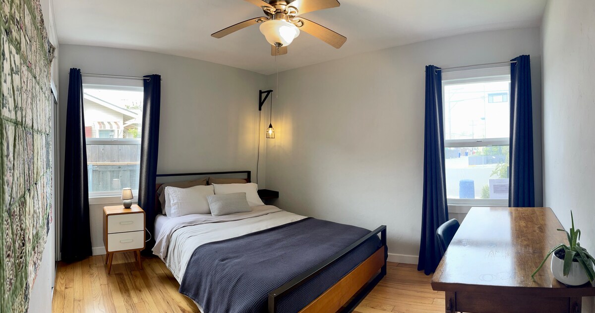 Front bedroom, large desk and queen bed.  Closet with drawers and hangers.