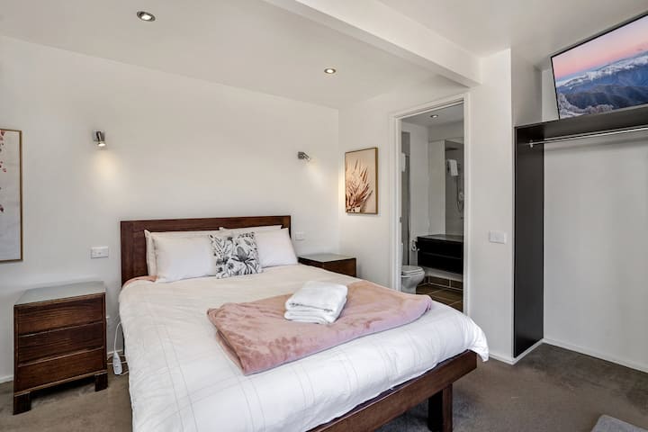 This is the bedroom on the lower floor.  stair to the main living area upstairs. There is a panel heater and a large sliding door to outside. 

Photo taken May 2021