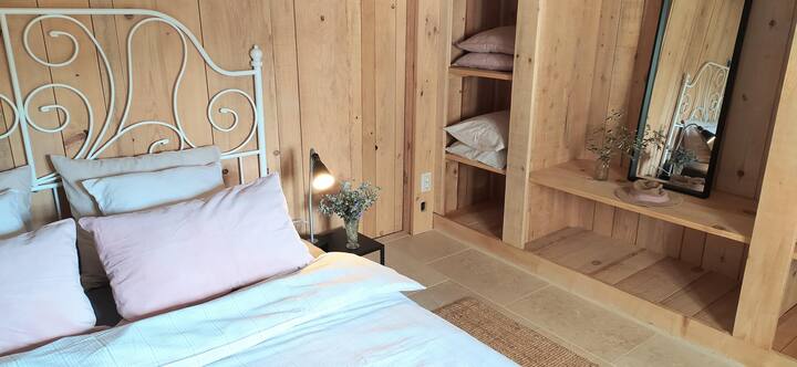 Chumba cha kulala nr. 2 kwenye ghorofa ya kwanza. Mchanganyiko wa kuta za mbao na mawe.