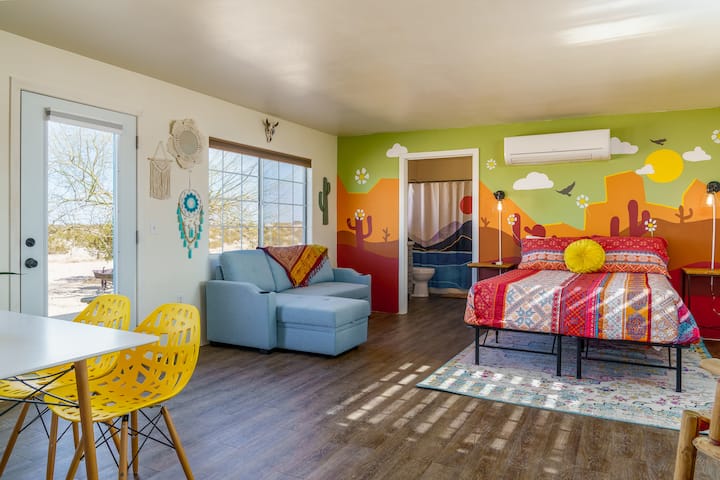 Colorful desert-inspired room features a colorful mural of mountains, cacti, and desert skies that brings the space to life. 