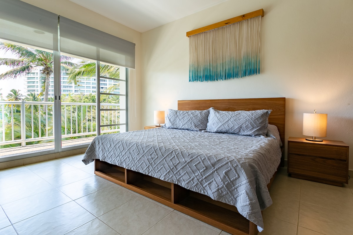 Cama king size en recámara principal con salida al balcón.