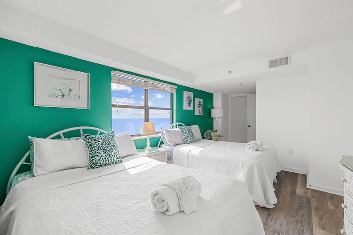 Dormitorio secundario con dos camas tamaño queen y una hermosa vista al mar.  