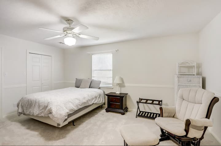 Втора спална соба со два брачни кревета (едниот не е прикажан на другата страна од ноќната масичка), плакари, голем телевизор со рамен екран, удобен стол за лулање и многу простор за фиоки. 