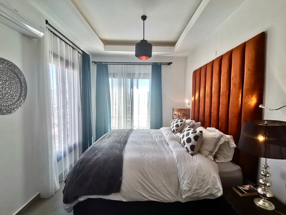 Een super kingsize bed (2 m)bezet de hoofdslaapkamer met een handgemaakt fluwelen hoofdeinde in een koperen tinten. Antieke verlichting is een aanvulling op het kleurenschema.