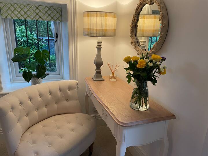 Dressing table (hairdryer) with chair, lamp and mirror. Picture box window overlooking the side garden.