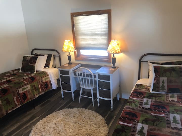 Spacious guest room with two cozy twin beds and work space. 