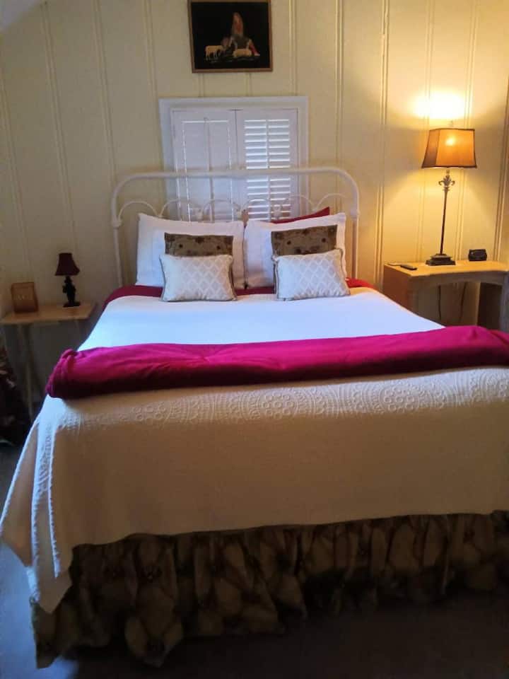 Habitación 2 Cama queen adornada con sábanas merlot de diseño y manta decorativa