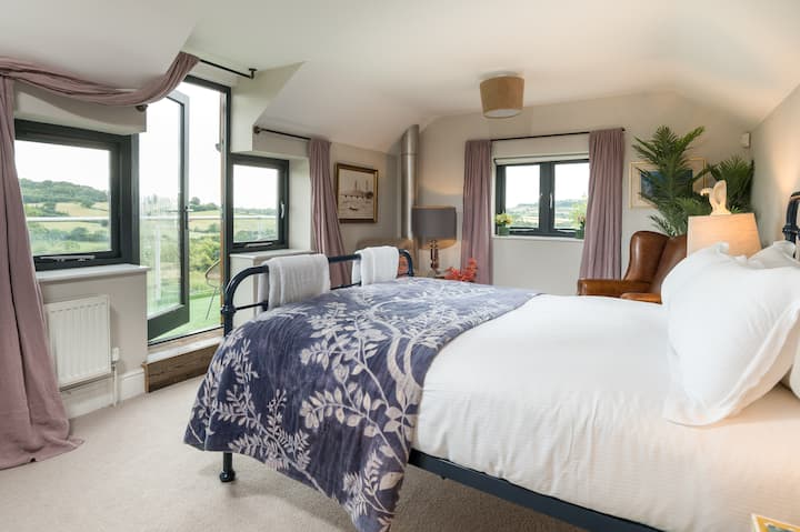 Dormitorio Una habitación azul con balcón, cama king size y baño en suite 