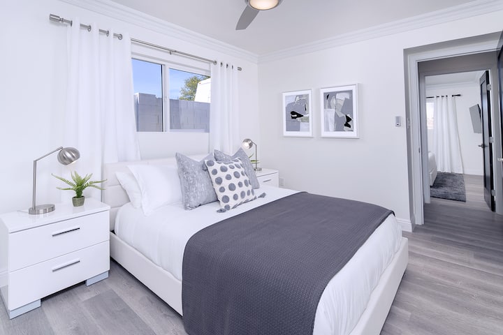 Chumba cha kulala cha 3 kina kitanda cha ukubwa wa malkia na meza mbili za usiku zenye droo, na feni ya dari.