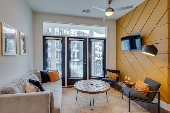 Super comfy velvet couch with two chairs and a smart tv - right off the living room is a large corner balcony overlooking the courtyard.