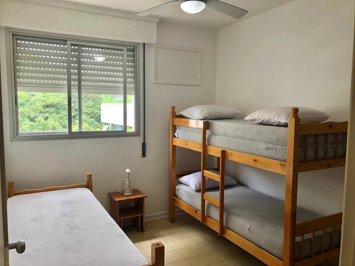 卧室配有双层床、单人床、单人床垫和天花板风扇。