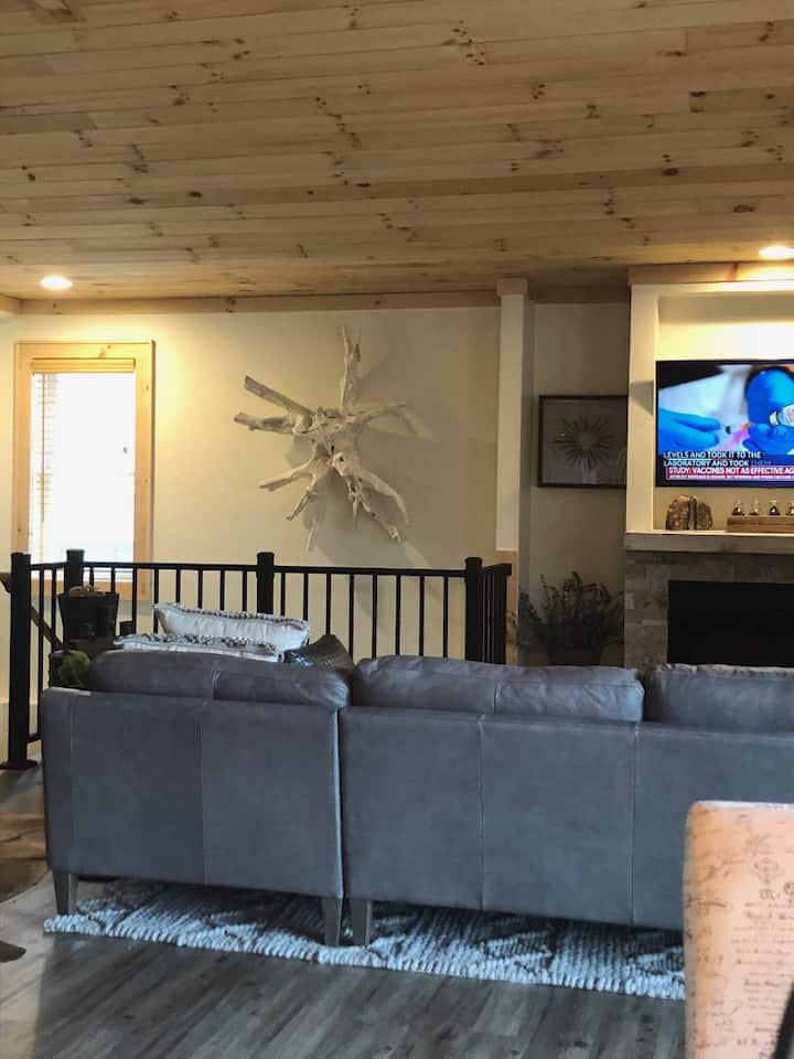 Une vue depuis la salle à manger sur le salon.  Jetez un œil à cette immense sculpture murale en bois flotté.  Tellement unique et adapté à cette ambiance de chalet de ferme rustique. 