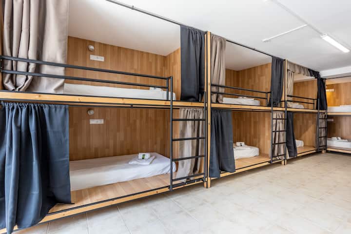 8 camas em dormitório misto com privacidade, compartimento fechado por cortina. Todas as camas têm tomada, porta usb e luz individual. O dormitório tem 2 cabines de w.c e 2 cabines de duche no seu interior.