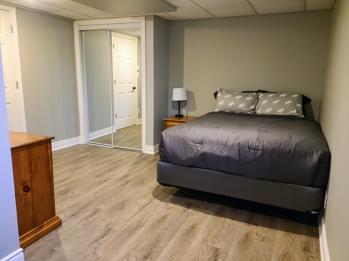 غرفة نوم كبيرة بسرير بحجم ملكي وخزانة ملابس وخزانة ملابس مزدوجة.