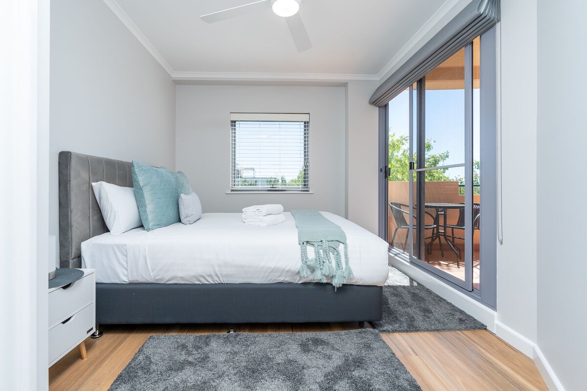 Primárna a čistá biela spálňa s posuvnými sklenenými dverami. Balkón je hneď pred touto spálňou.