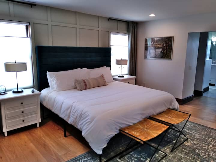 Spacious master bedroom suite on the main floor, with private fireplace, TV, and sunroom / backyard access.