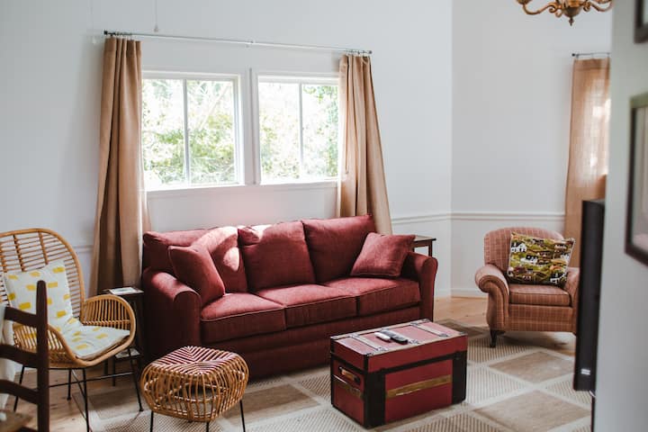 Living room with queen sofa bed, seating, and smart TV