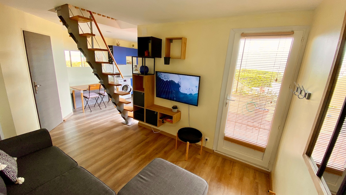 Всекидневната, телевизорът, свързаният с интернет телевизор, гледката към плажа и разтегателния диван...