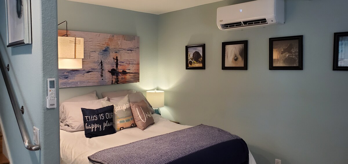 La cama queen ajustable y el aire acondicionado exclusivos de la suite con el control en la pared.