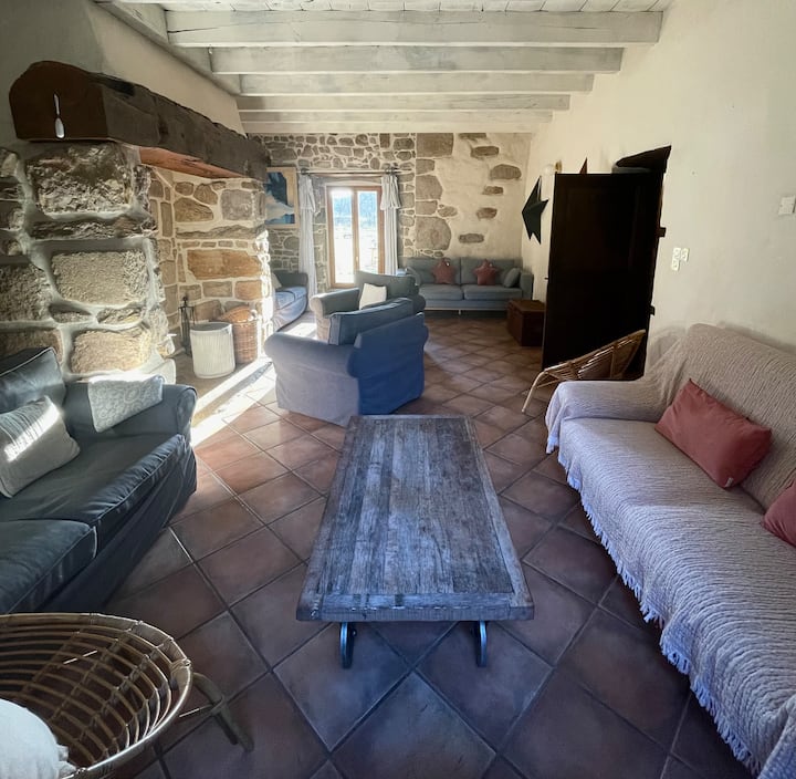 El acogedor salón, aparte (30 m2) con sus numerosos sillones y sofás. Una estufa de leña, una gran TV con Netflix y juegos de mesa.