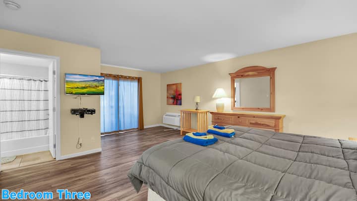 Basement Level Bedroom #3: Single King-size bed with a private full bathroom, pub table, patio access, and cable TV.