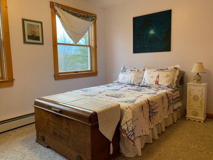 4th bedroom has a full/double bed, a dresser, a closet with shelves, and a great view out toward Ragged Mountain and the back yard