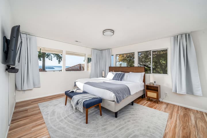 Camera da letto matrimoniale con letto king-size.  TV montata. Panorama sull'acqua e sulle montagne.  Cabina armadio collegata con cassettiera e bagno padronale con doccia per due persone e 2 soffioni doccia indipendenti!