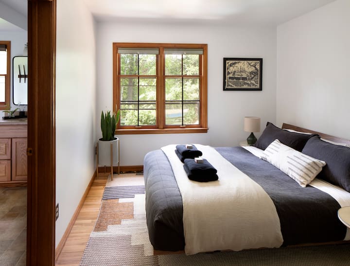 Master bedroom featuring en-suite bathroom, cal-king size bed, office-nook, and river views.