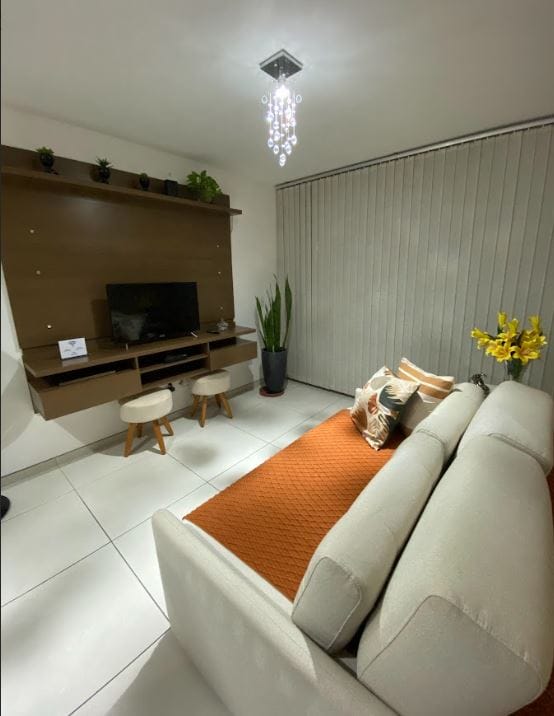 En la sala de estar, encontrarás un televisor Smar de 50pulgadas, dos taburetes y una mesa de apoyo, un sofá cama, una puerta de vidrio con acceso al balcón con persianas.