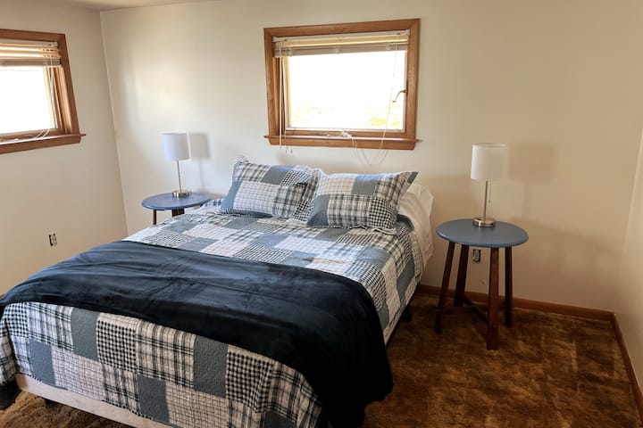 The rear bedroom has a queen bed. The lamps have USB ports to charge your phone. There is a window that looks out to the water.