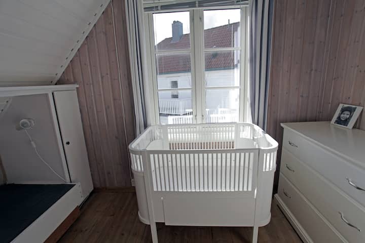 儿童房，配有婴儿床和婴儿床，与主卧相连