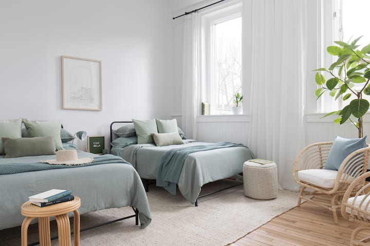 Sage bedroom with two full size beds and sitting area.