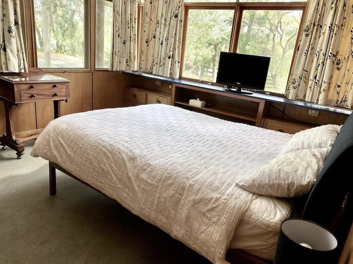 ห้องนอนใหญ่พร้อมห้องนอนขนาดควีนไซส์และเสื้อคลุมและลิ้นชักในตัวห้องน้ำเฉพาะ