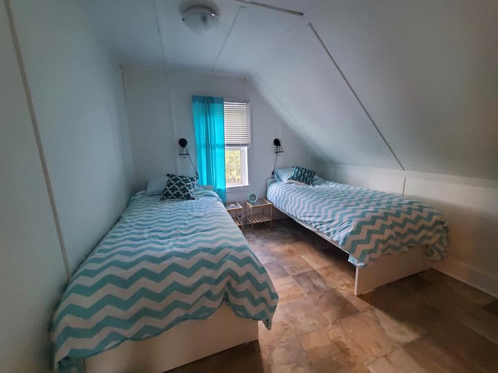 Druga spavaća soba na katu s dva odvojena kreveta.