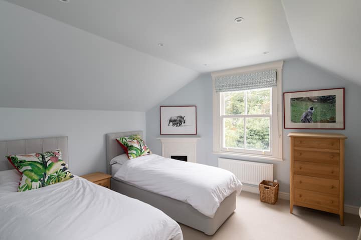 Dormitorio 4 con camas individuales, colchones de lujo, TV y un montón de espacio para guardar, con vistas a los hermosos jardines.