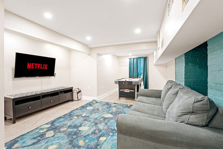 Perfect for extra guests or family fun—this inviting bonus lounge features a large smart TV, air hockey table, and a comfy seating area that converts into a fully made sofa bed.