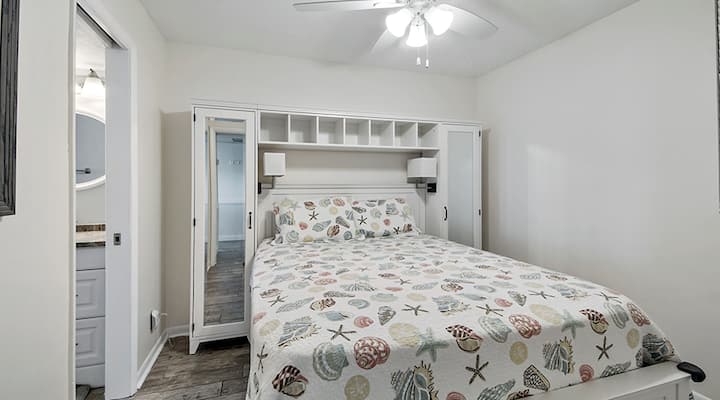 Menšia manželská posteľ so stropným ventilátorom a káblovou