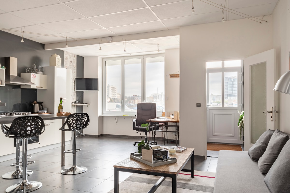 غرفة معيشة مشرقة في الطابق الأرضي مع نافذة ذات تأثير مرآة، وتوفر إطلالات على الميناء التجاري مع الحفاظ على خصوصيتك