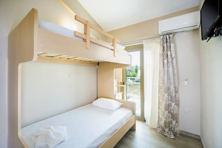 Ნათელი და მყუდრო საძინებელი ორსართულიანი საწოლებით, აუზის იატაკზე.