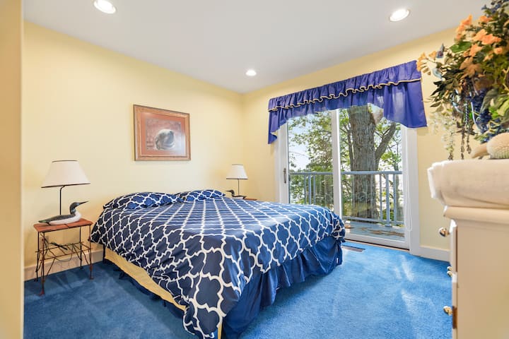 חדר אורחים שני עם הליכה למרפסת ונוף לאגם ליד המיטה.  מיטת קווין סייז.