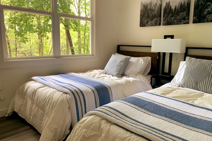 Dormitorio con dos camas individuales y mucha luz natural