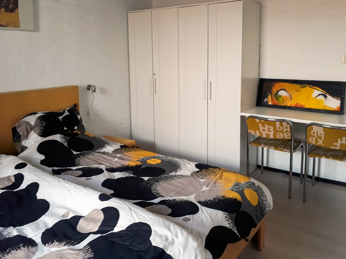 غرفة نوم كبيرة مع مكتب وكرسيين إضافيين