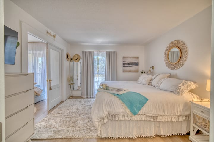 通风宽敞的卧室，可欣赏部分海滩景观；磨砂法式门通往第二间卧室