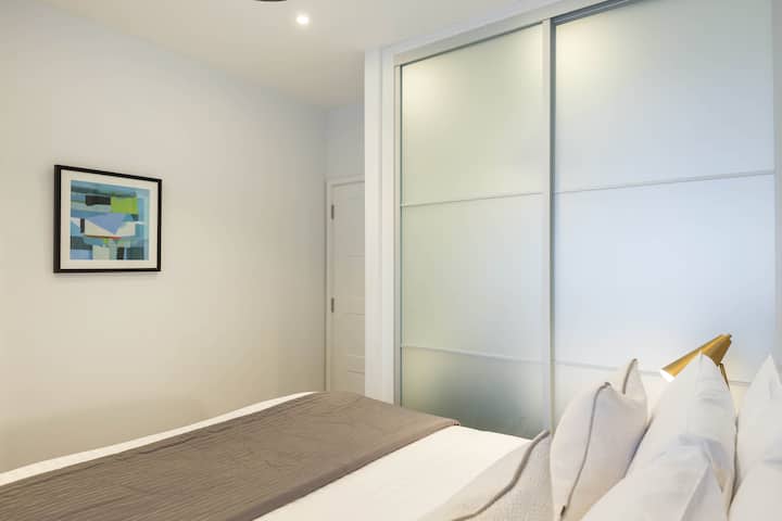 Просторна спална соба со елегантен ентериер и гардероба.