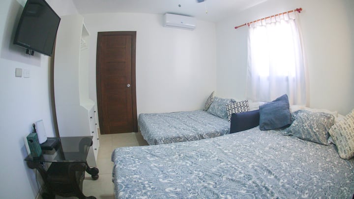 Chumba cha televisheni kilichotengenezwa kama chumba cha kulala cha 5 - kitanda cha futoni chenye ukubwa maradufu kwenye mandharinyuma na kitanda cha Queen size Sofa upande wa mbele. Pia  kifua cha droo, Televisheni mahiri yenye chaneli 300, A/C, bafu la kujitegemea - ( sawa na chumba cha 4 cha kulala/bafu kwa ukubwa)