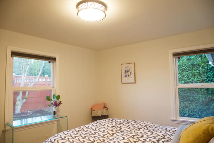 ห้อง #1: ห้องนอนชั้นหลักพร้อมเตียงควีนไซส์ วิวสวนหลังบ้านจากหน้าต่าง 