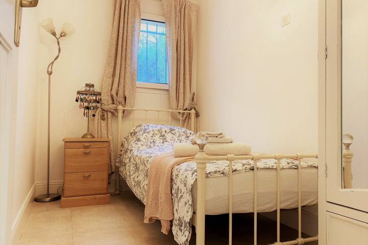 Единечна спална соба со огледална гардероба.