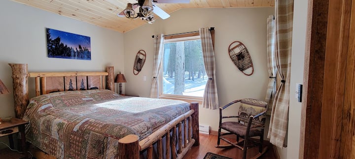 Nueva suite principal con ventanas con marco de fotos con vistas al bosque.