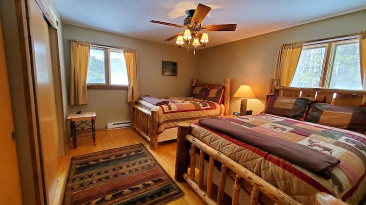 Dormitorio de invitados con dos camas de tamaño completo y otro televisor